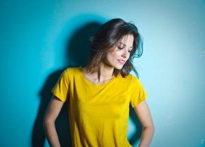 brunette woman in yellow shirt smiling