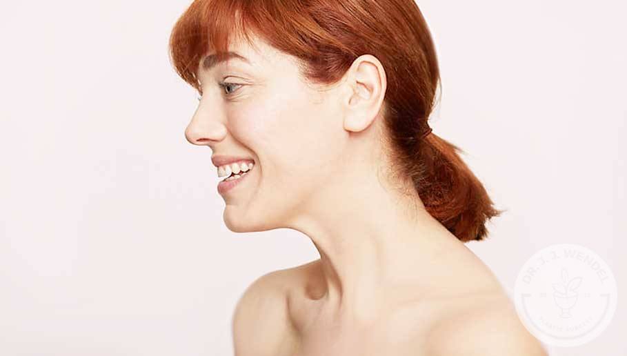woman with red hair smiling looking to side