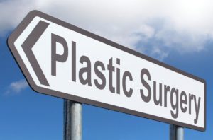 sign reading plastic surgery against blue sky