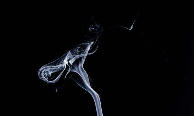 cigarette smoke against black background