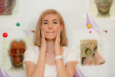 blonde woman holding her face in her hands