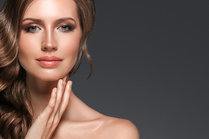 womans face and neck against black background