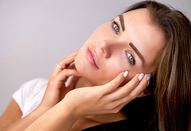 woman with hands on face looking at camera