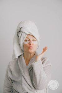 woman in towel and robe with eye masks