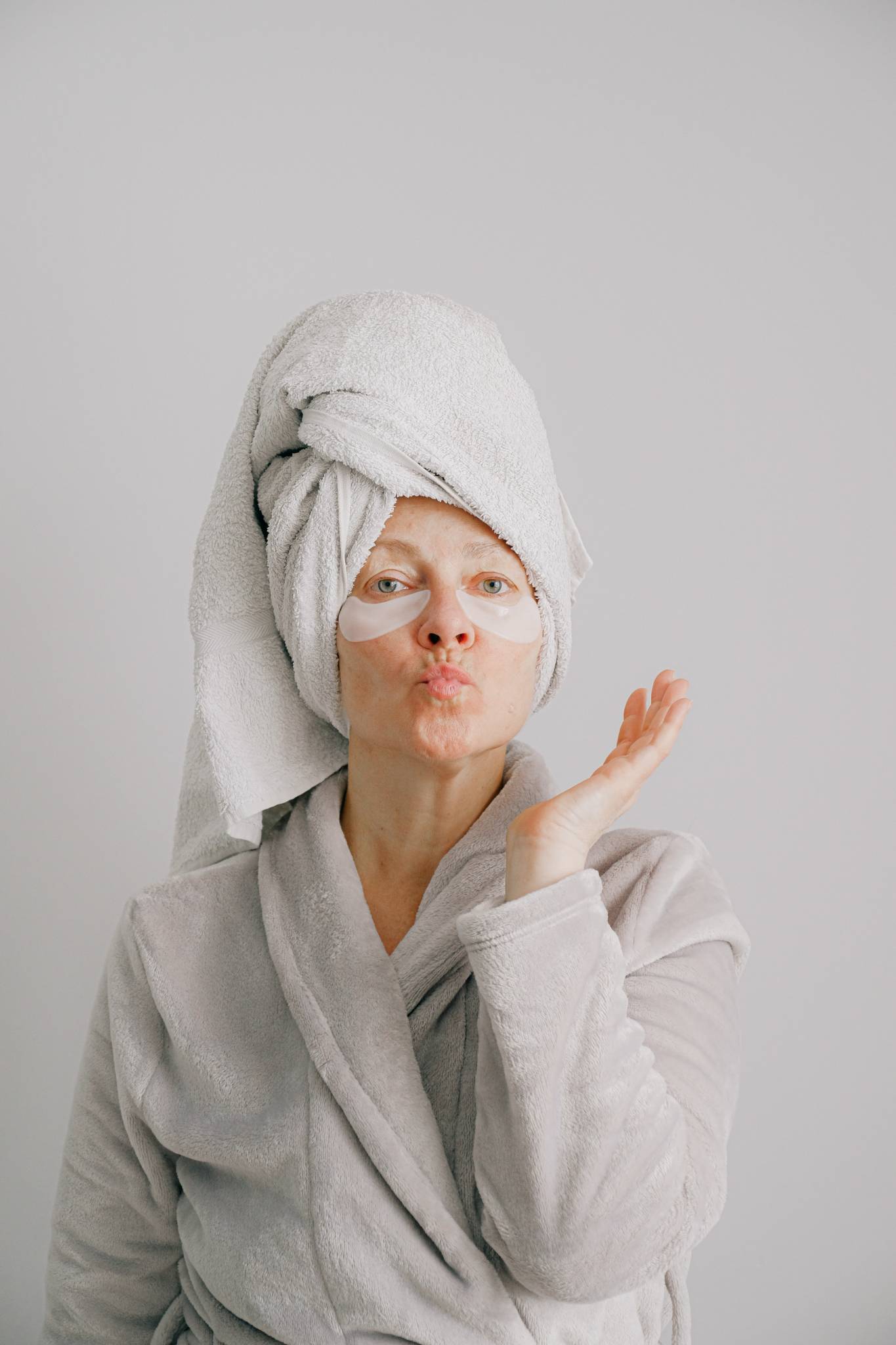 woman in towel and robe with eye masks