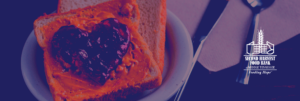 Open-faced peanut butter and jelly sandwich with purple jelly in the shape of a heart