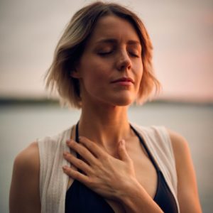Blonde woman with eyes closed and hand on chest