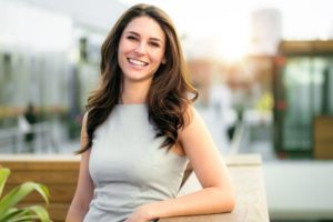 brunette woman smiling after recovering from breast reduction surgery