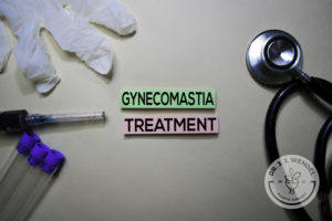stethoscope and medical glove next to pink and green label reading "gynecomastia treatment" in black letters