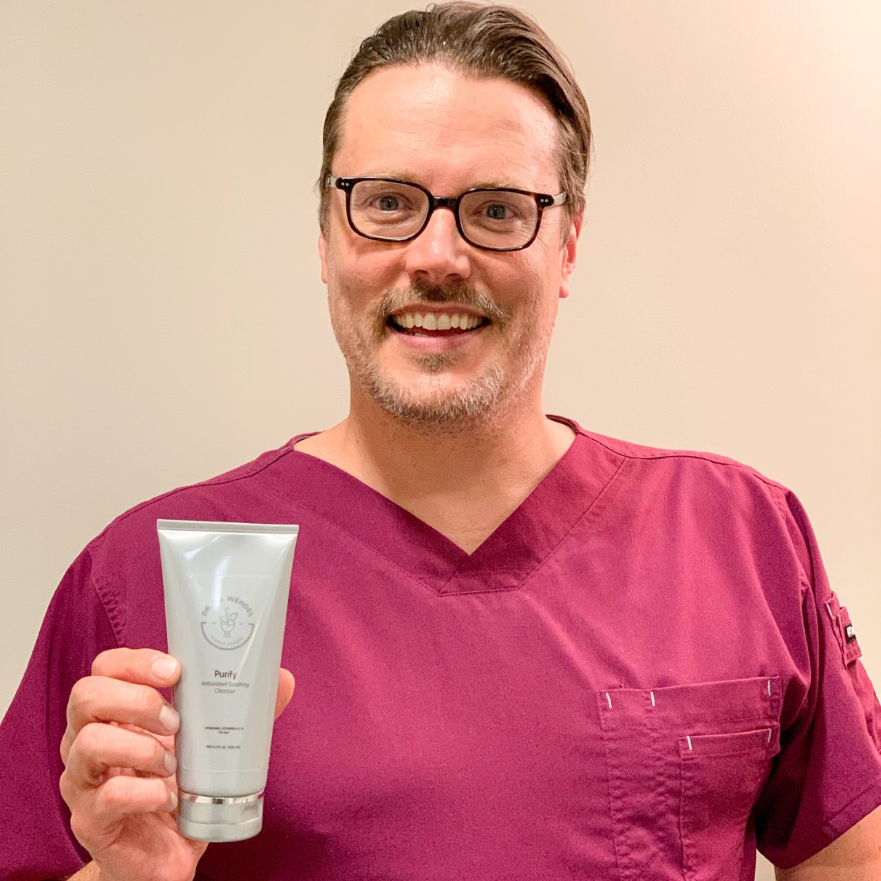 Dr. J. J. Wendel holding up men's skincare product