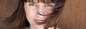 Smiling caucasian woman with short brown hair and brown eyes