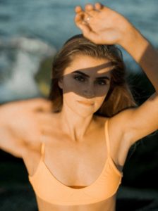 Young, caucasian women with brunette hair in orange bikini top