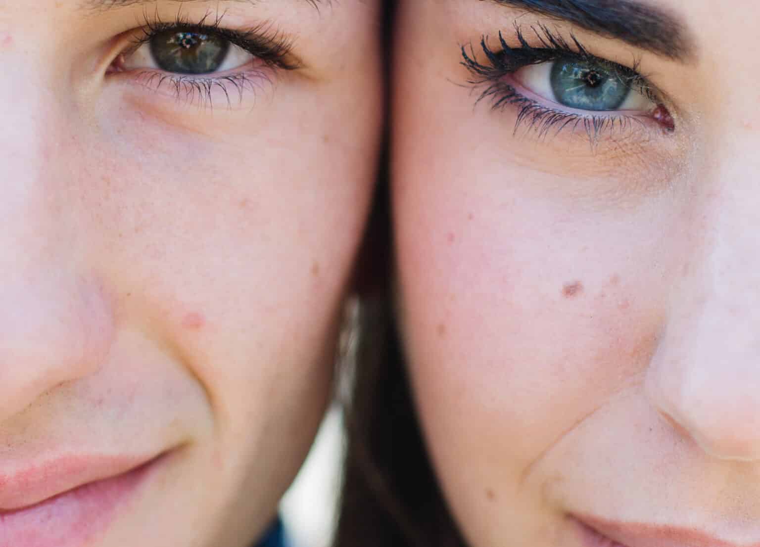 a zoomed in image of two caucasian faces with their cheeks touching