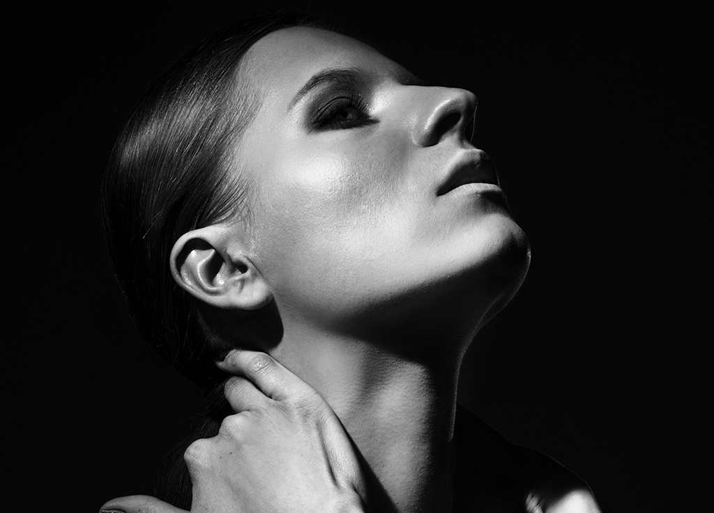 black and white photo of a woman looking up with her eyes closed