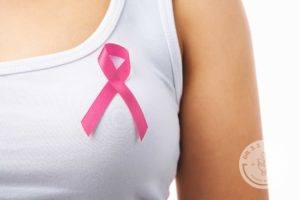 woman in white tank top wearing pink breast cancer awareness ribbon