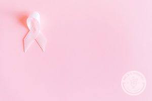 Pink breast cancer ribbon with a pink background