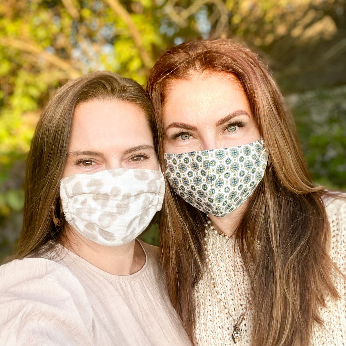 Two young brunette women smiling wearing face masks