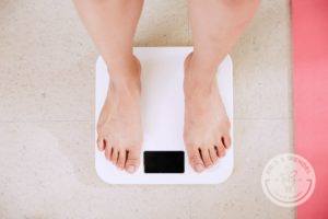 Woman stepping on white scale