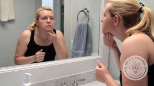 Girl looking at face in mirror