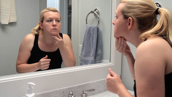 Girl looking at face in mirror