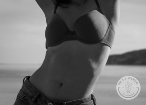 black and white image of woman wearing bra and jeans