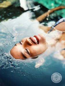 woman floating in a body of water with face above water
