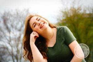 woman sitting outside with hand on face