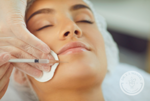 women with eyes closed receives injectable filler in chin