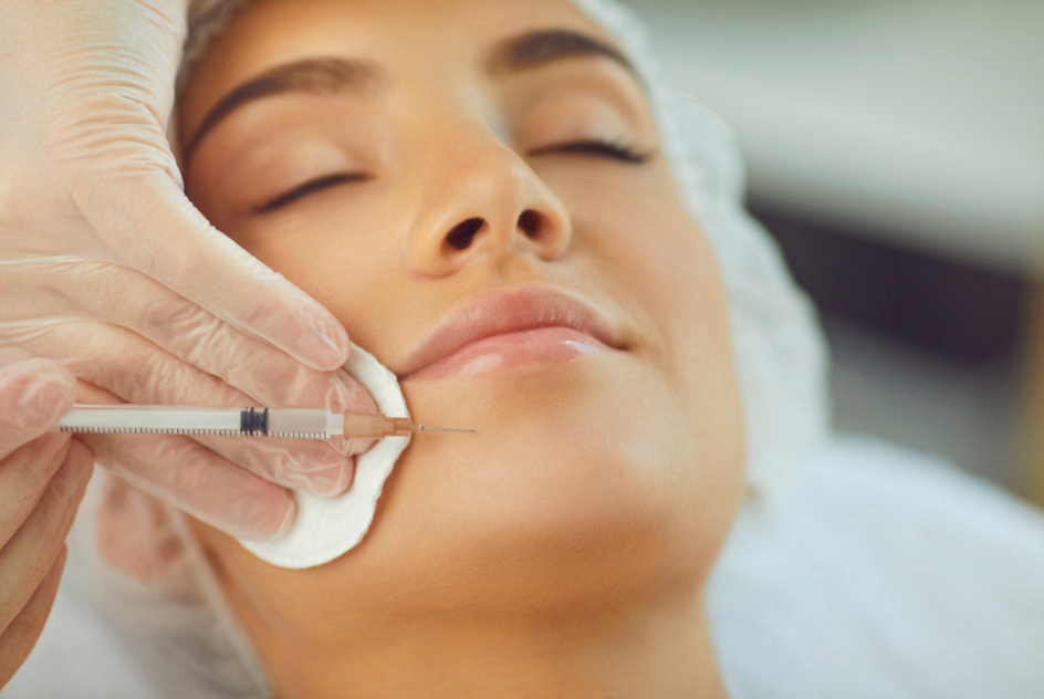women with eyes closed receives injectable filler in chin