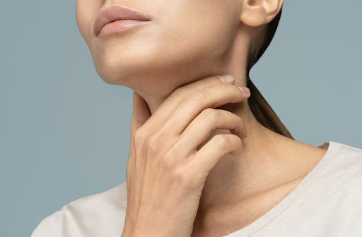 view of women's lower face with her hand placed on her neck