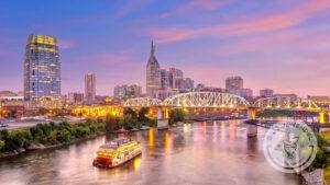 Landscape of Nashville skyline with pedestrian bridge and boat in foreground