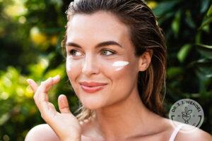 woman outside smiling putting moisturizer on cheeks