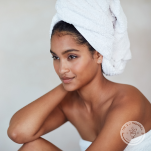 woman with hair wrapped in a bath towel gazes to the left