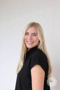 blonde haired woman wearing black shirt smiling at camera
