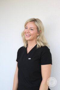 Blonde woman with blue eyes turned slightly left and smiling