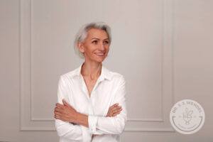 Close up portrait of beautiful older woman standing by wall