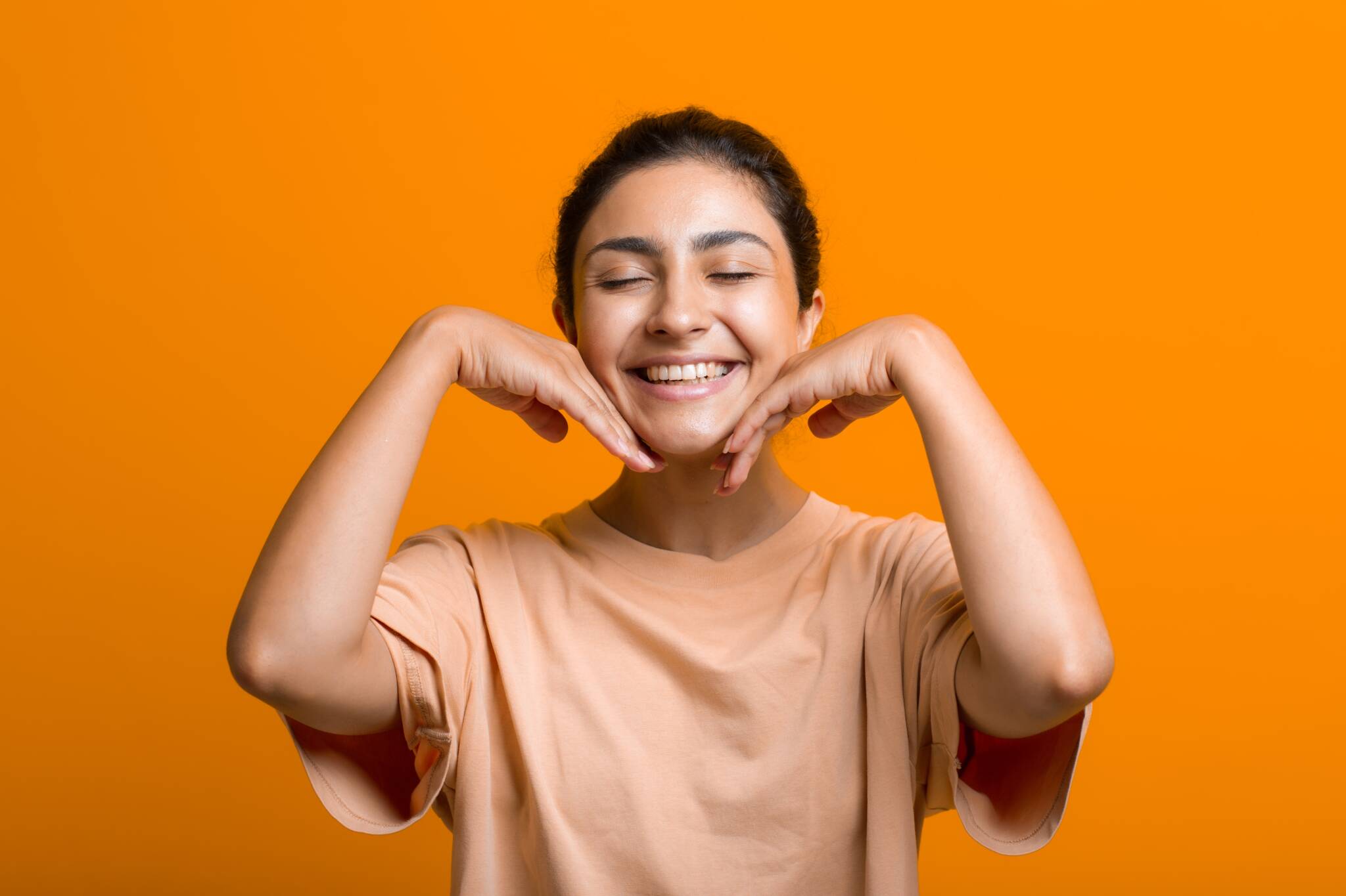 Young woman feeling her jaw and cheeks with back of fingers