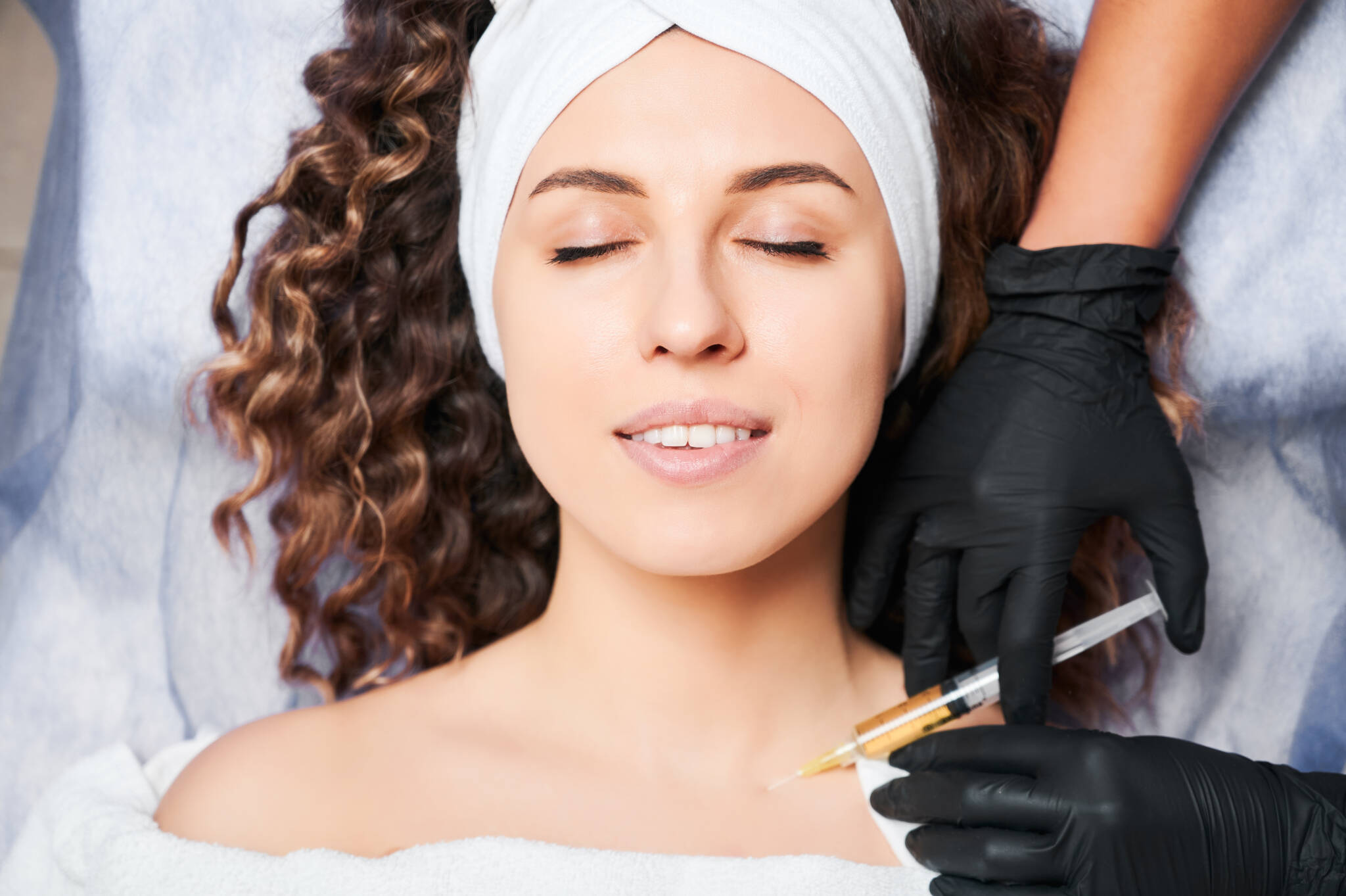 Woman getting minimally invasive injections in neck to prevent wrinkles.