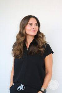Brunette woman against white wall looking away to the right