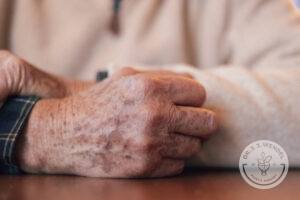 Close up of wrinkled hands on table