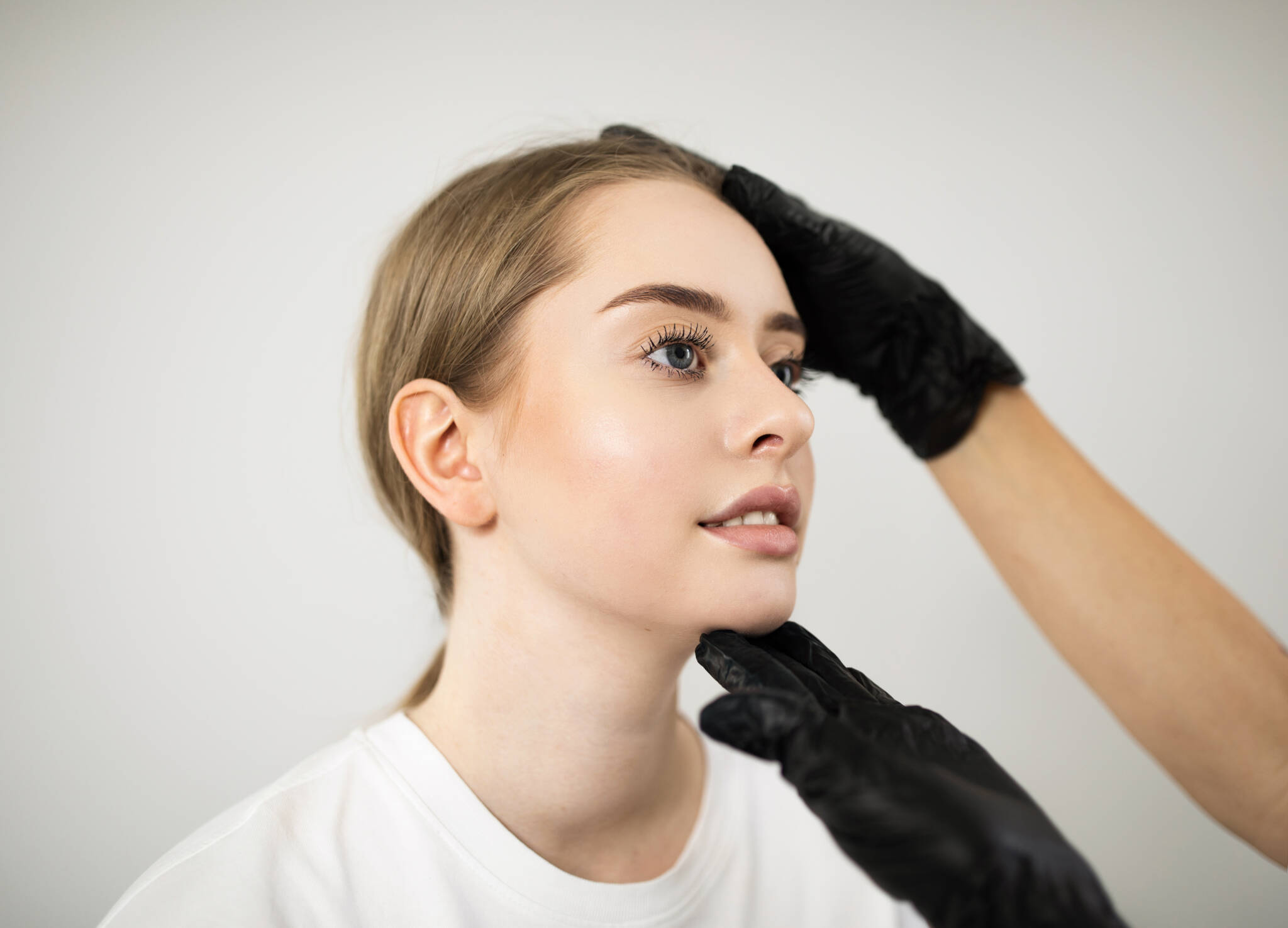 Person in black gloves touching the face of a young woman