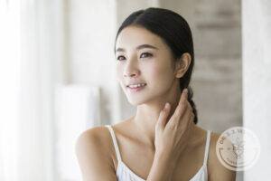 Young Chinese woman rubbing neck