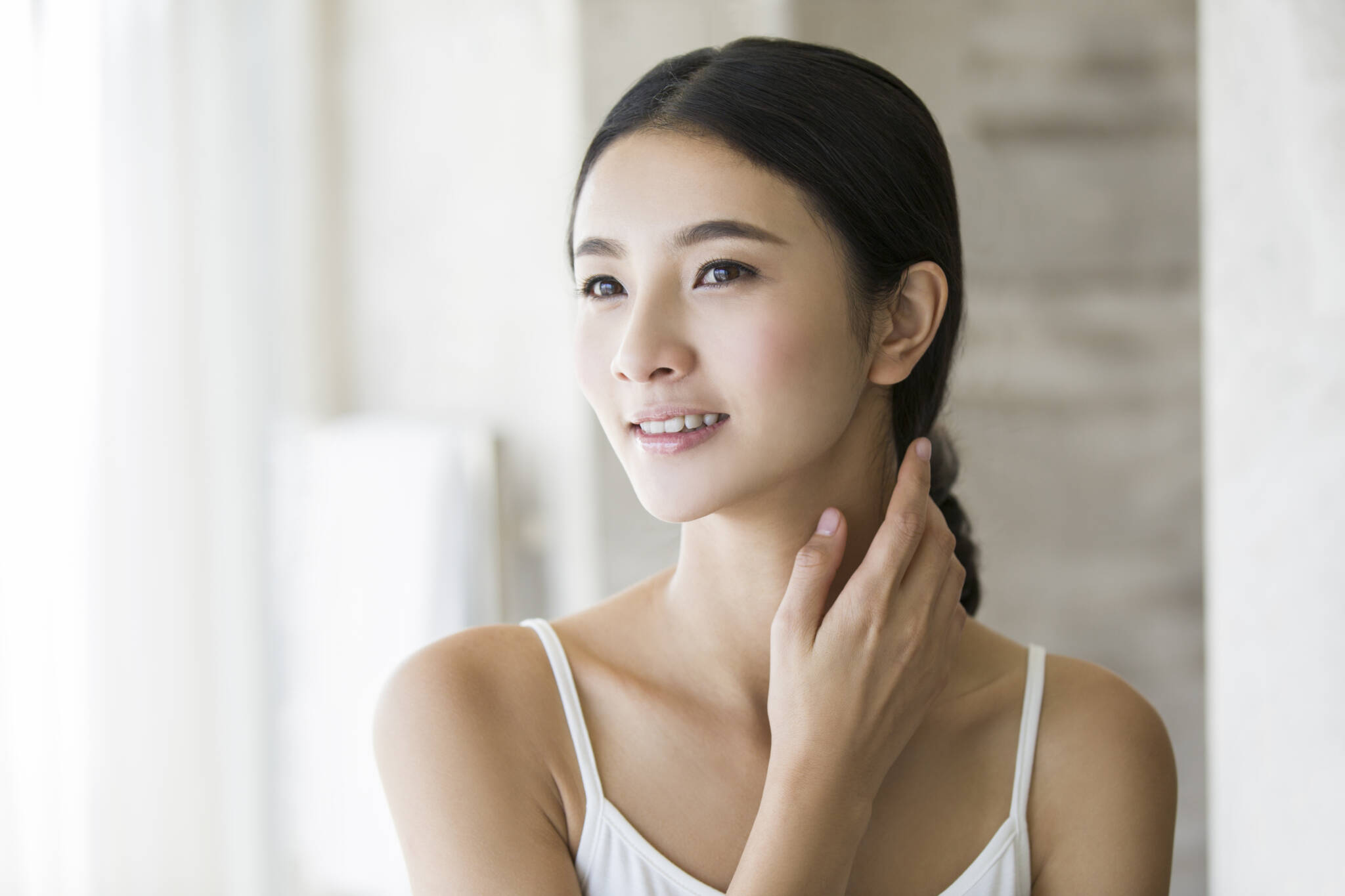 Young Chinese woman rubbing neck