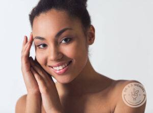 Smiling black woman resting her head against her clasped hands