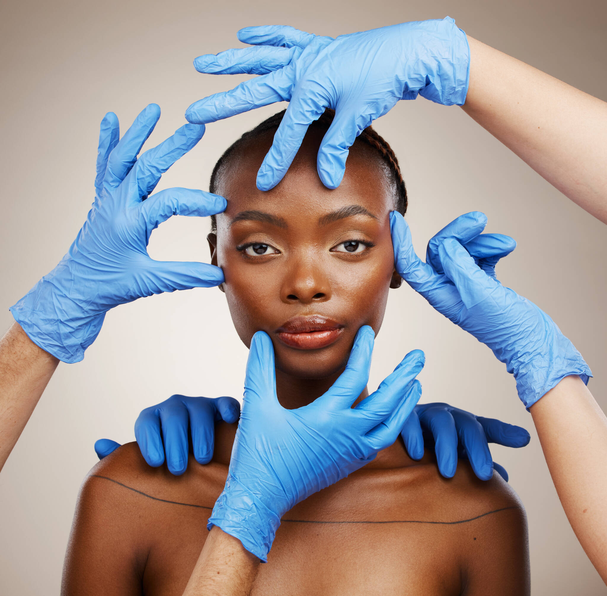 Six hands in blue gloves touching and pulling black woman's face