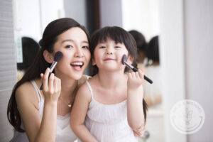 Chinese mother and daughter putting on makeup