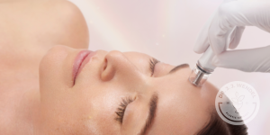 Woman laying down with her eyes closed while receiving a facial treatment