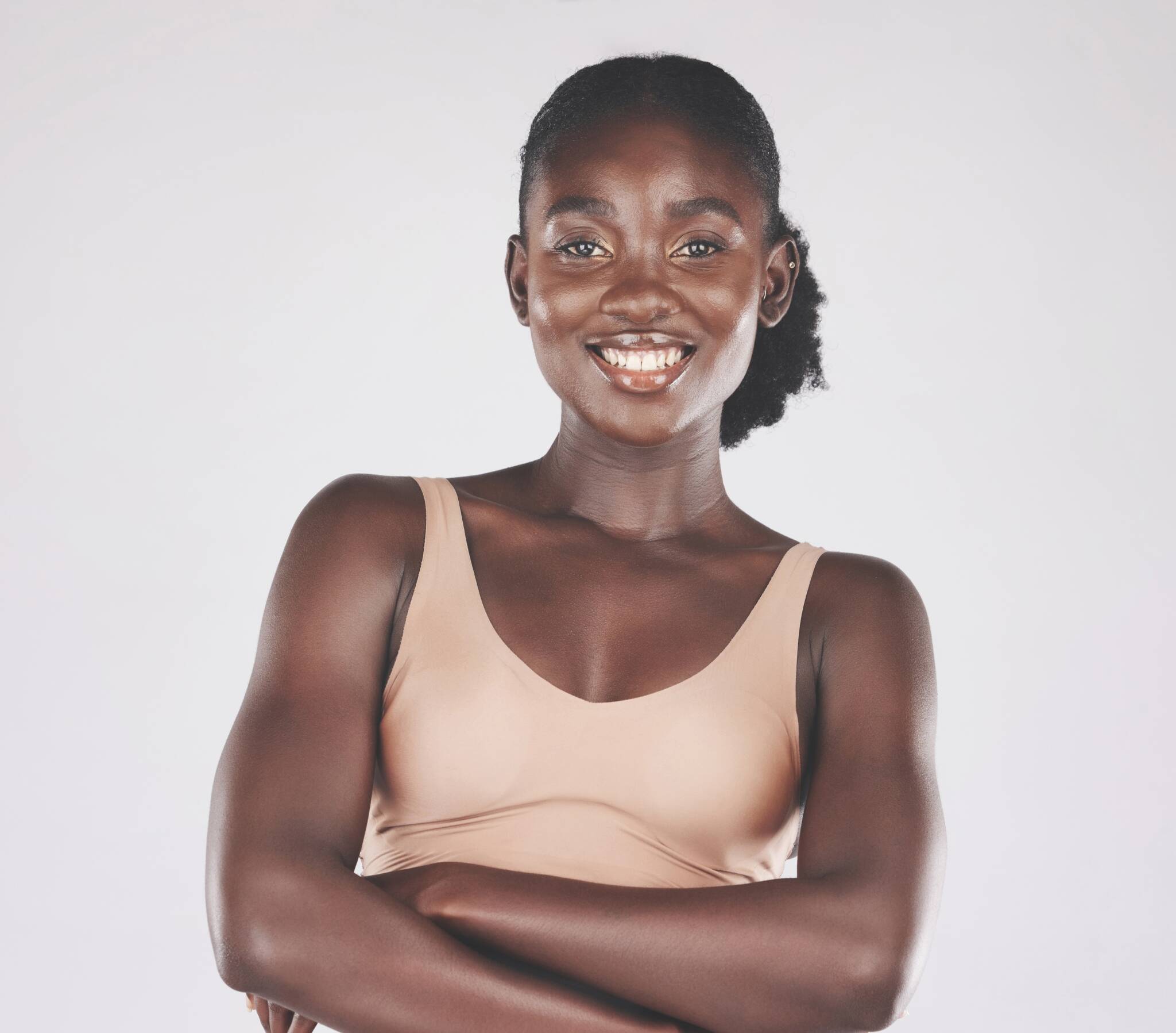 Black woman smiling while wearing a beige bra and matching underwear