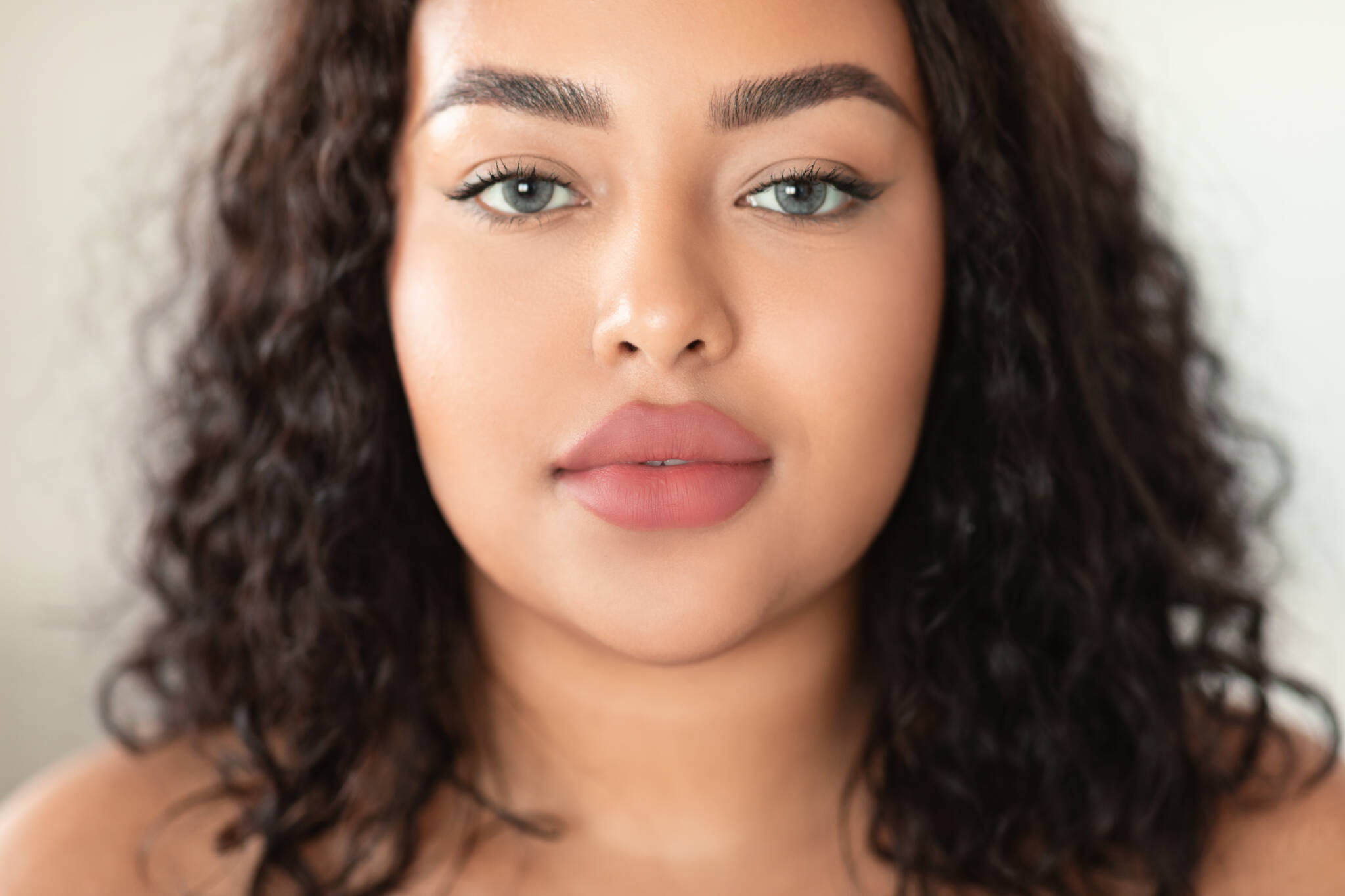 Beautiful woman with full lips and curly brown hair