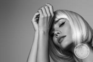 Woman with short blonde bob leaning on her arms